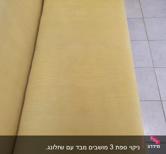 ספה צהובה נקייה על רצפת אריחים אפורה
